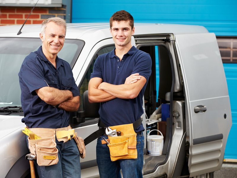 Two workmen stood in front of a van